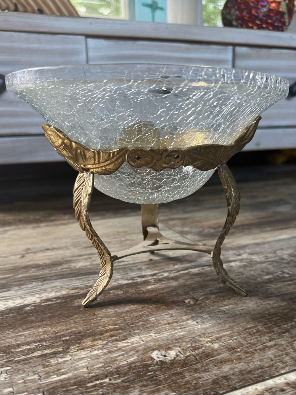 vintage crackle glass bowl housed in an ornate brass tripod stand